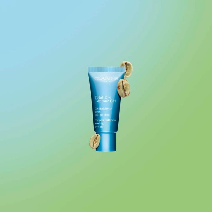Clarins Total Eye Contour Gel 20 ml viilentävä silmänympärysgeeli laskee turvotusta sinisessä tuubissa kahvipapujen kera.