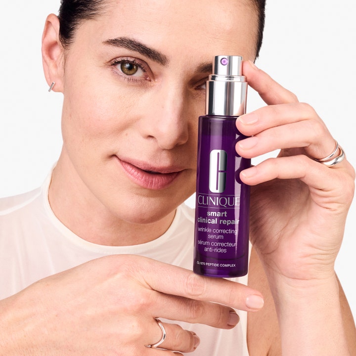 Clinique Smart Clinical Repair 100 ml ryppyjä silottava seerumi nainen pitelee purppuraa pumppupulloa