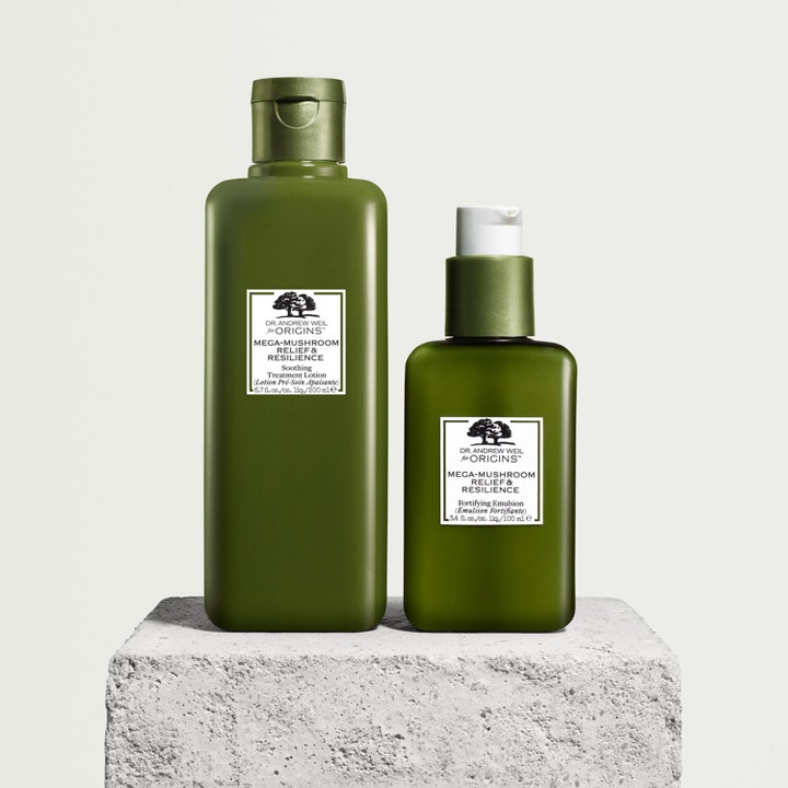Origins Dr. Weil Mega-Mushroom 200 ml hoitovesi ja 100 ml emulsio vihreissä pulloissa kivijalustalla.