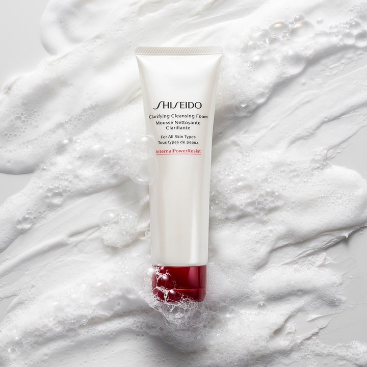 Shiseido Defend Clarifying Cleansing Foam 125 ml kirkastava puhdistusvaahto valkoisessa tuubissa ilmavan vaahdon keskellä.