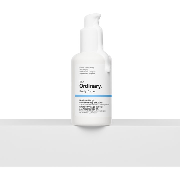 The Ordinary Niacinamide 5% Face & Body Emulsion 100 ml kirkastava voide valkoisessa pumppupullossa, jota pitkin valuu emulsiota.