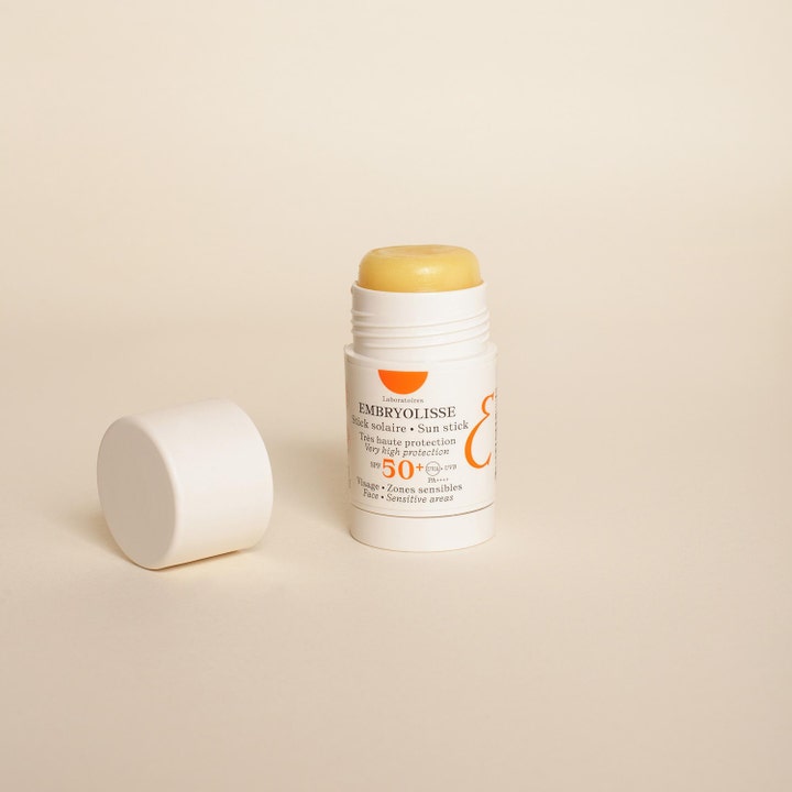 Embryolisse Sun Stick SPF50+ 15 g suojaava aurinkosuojapuikko avattuna valkoisessa hylsyssä kellertävällä koostumuksella.