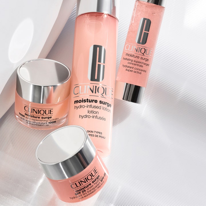 Clinique Moisture Surge SPF25 Sheer Hydrator 30 ml päivävoide hopeakantisessa purkissa muiden tuotteiden kanssa.