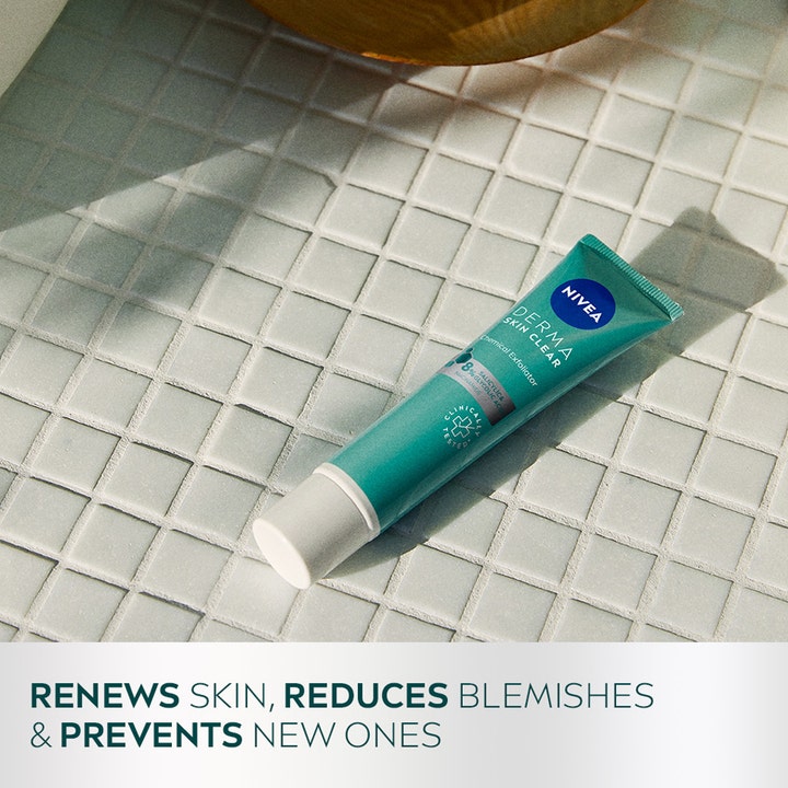 NIVEA Derma Skin Clear Night Exfoliator 40 ml kuoriva yövoide turkoosissa tuubissa kylpyhuoneen laatalla.