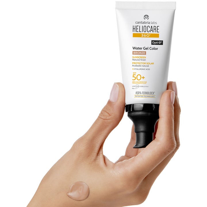 Heliocare Water Gel Color Bronze 50 ml suojakerroin 50+ aurinkovoide, valkoinen tuubi ja sävytetty pisara kädellä.