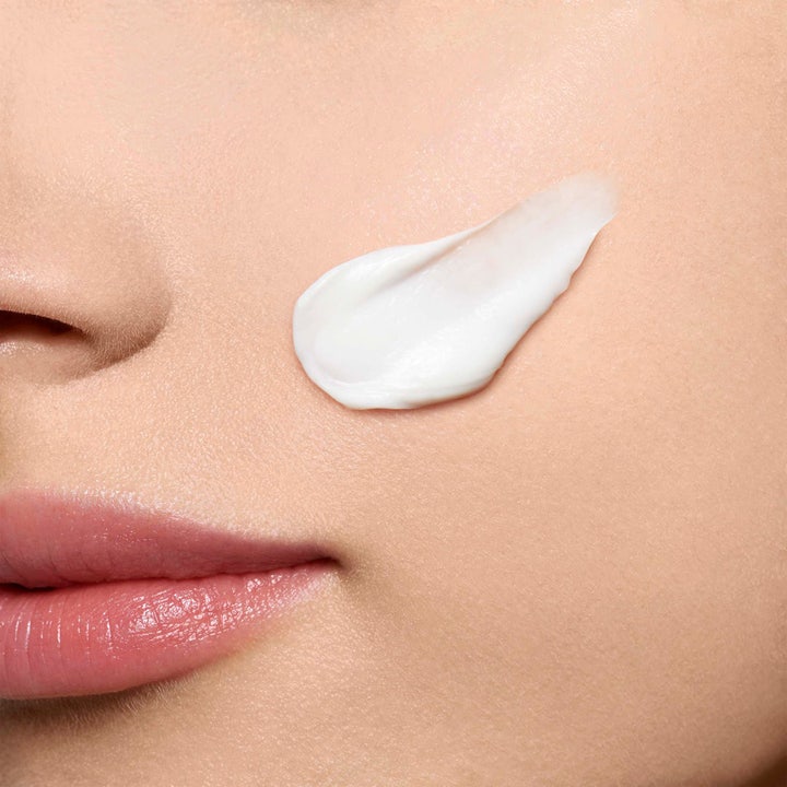 Clarins Hydra-Essentiel Rich Cream 50 ml ravitseva kasvovoide, täyteläinen valkoinen voidepyyhkäisy poskella.