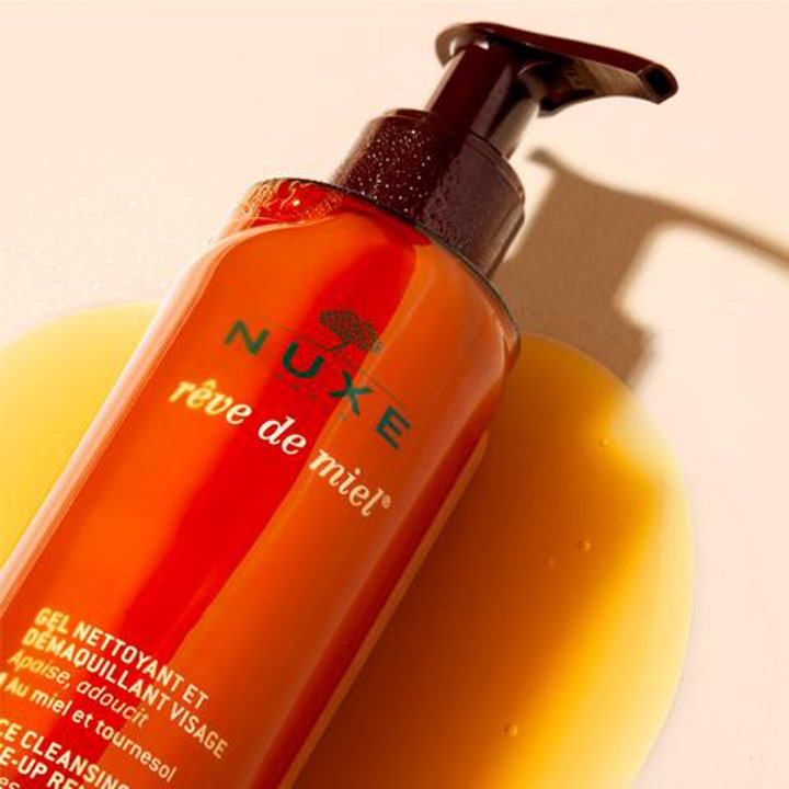 Nuxe Rêve de Miel 200 ml puhdistusgeeli kasvojen puhdistukseen oranssissa pumppupullossa hunajaisen geelin päällä.