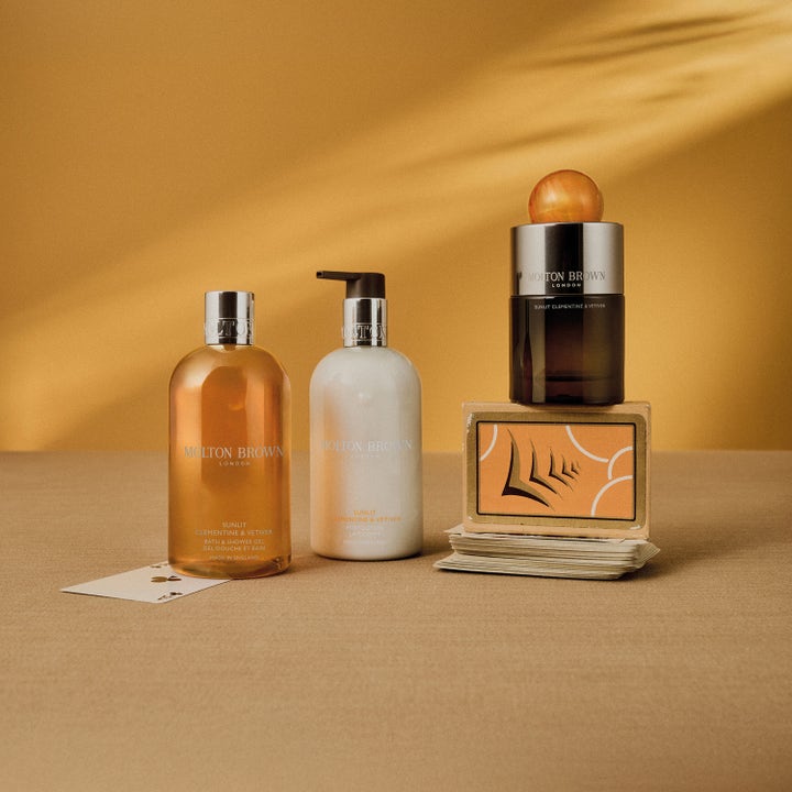 Molton Brown Sunlit Clementine & Vetiver 300 ml suihkugeeli osana aurinkoista tuotesarjaa keltaisella taustalla.