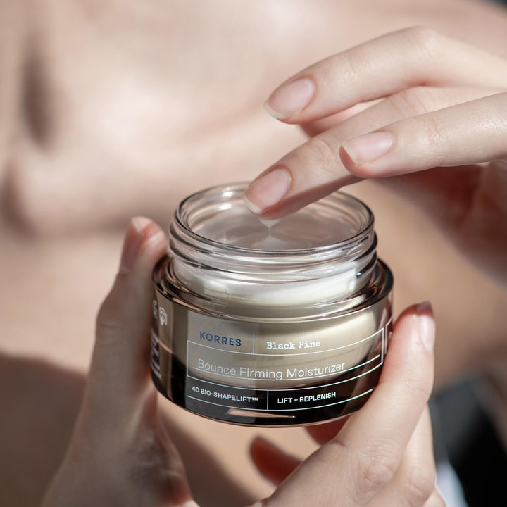 KORRES Black Pine 4D Bounce Firming Moisturizer 40 ml kiinteyttävä kasvovoide tummassa purkissa sormen koskettaessa voidetta.