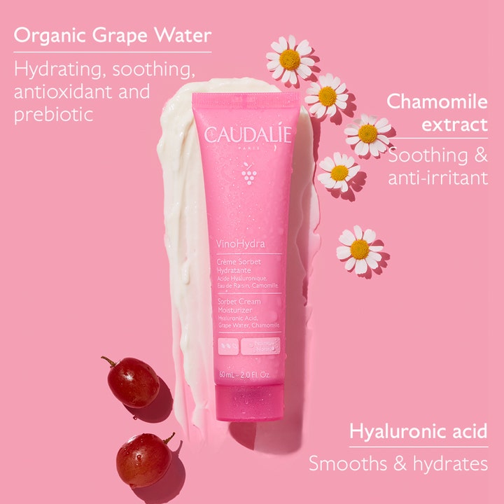 Caudalie Vinohydra Sorbet Cream 60 ml kosteusvoide vaaleanpunaisessa tuubissa valkoisen voiteen ja rypäleiden kera.