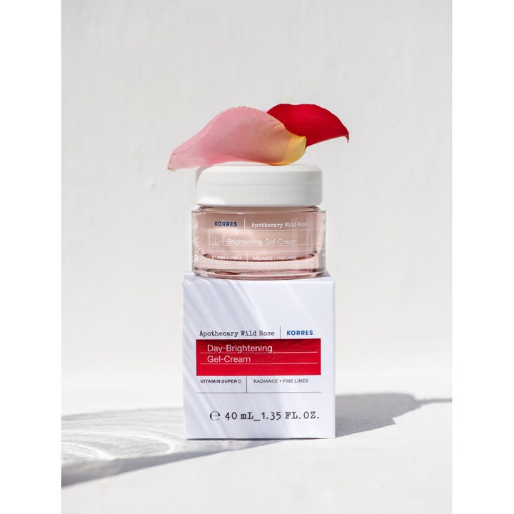 Korres Apothecary Wild Rose 40 ml kirkastava geelivoide lasipurkissa, jonka päällä on ruusun terälehtiä.