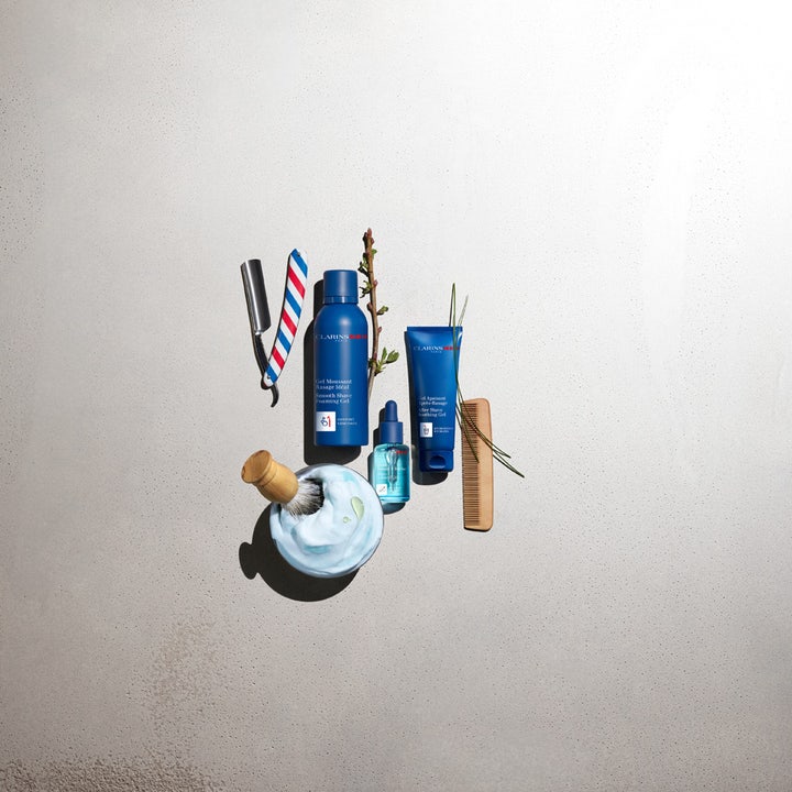 Clarins Clarins Men Shave Gel 150 ml pehmentävä partageeli sinisessä pullossa partasudin ja vaahdon keskellä.