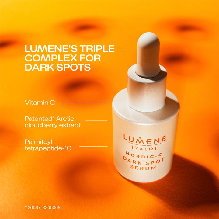 Lumene Dark Spot Serum 30 ml kirkastava seerumi C-vitamiinilla valkoisessa pipettipullossa oranssilla taustalla.