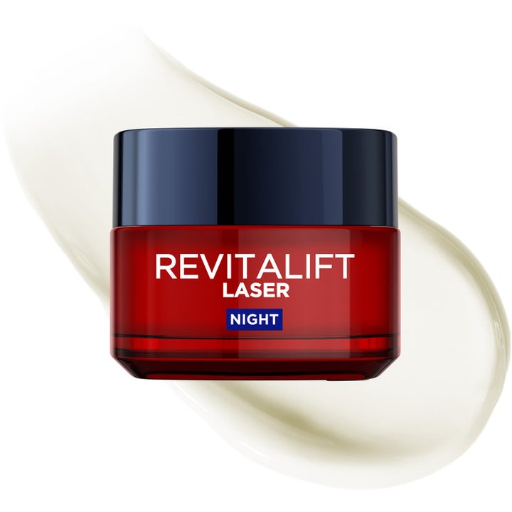 L'Oréal Paris Revitalift Laser Night 50 ml uudistava yövoide punaisessa lasipurkissa vaalean voidevedon päällä.