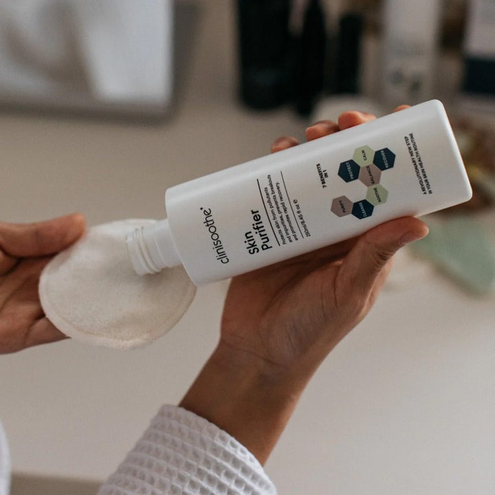 Clinisoothe Skin Purifier 250 ml rauhoittava kasvovesi valkoisessa pullossa, josta kaadetaan tuotetta vanulapulle.