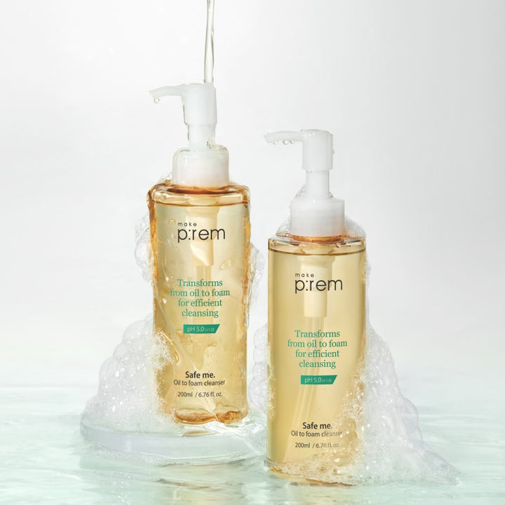 Make Prem Safe Me Oil To Foam Cleanser 200 ml puhdistusöljy kaksi pulloa vaahtoavien kuplien ja vesiroiskeiden keskellä.