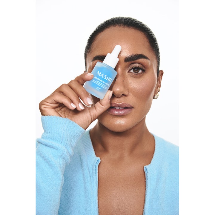 MASHH Gentle Moist Serum 30 ml kosteuttava vegaaninen seerumi vaaleansinisessä pipettipullossa naisen kädessä.