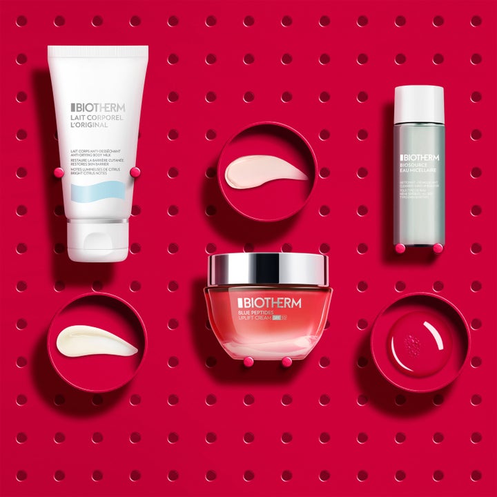 Biotherm Blue Peptides SPF30 Set ihonhoitosetti näyttää kiinteyttävän voiteen ja koostumukset vaaleanpunaisella taustalla.