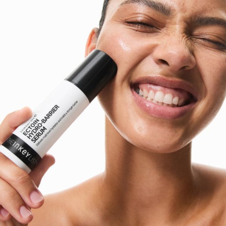 The INKEY List Ectoin Hydro-Barrier Serum 30 ml kosteuttava seerumi jota pidetään vasten hymyileviä kasvoja.