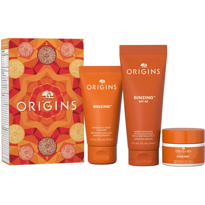 Origins GinZing 30 ml ja 50 ml kirkastava ihonhoitosetti oransseissa tuubeissa ja purkissa kuviollisen rasian kera