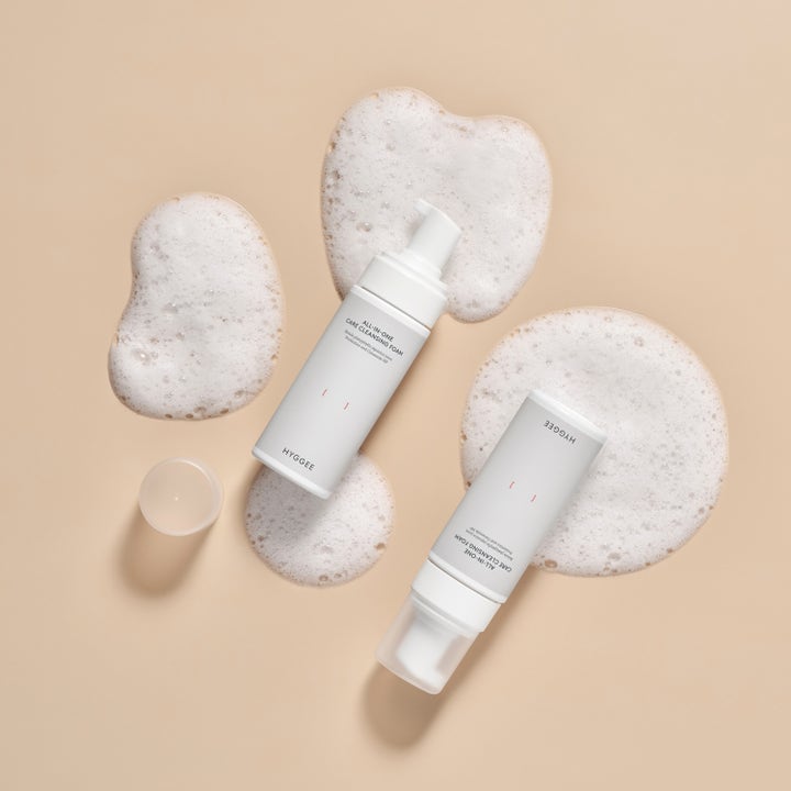 Hyggee All-In-One Care Cleansing Foam 150 ml puhdistusvaahto valkoisissa pumppupulloissa ja ilmavaa valkoista vaahtoa