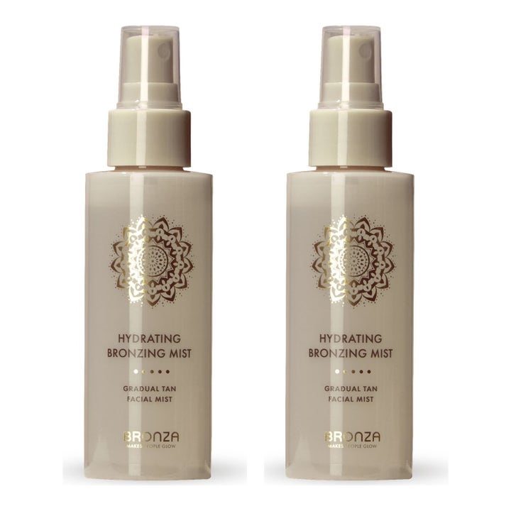 Bronza Hydrating Bronzing Mist kaksi kosteuttavaa itseruskettavaa suihketta kirkkaissa pulloissa kultaisella kuviolla