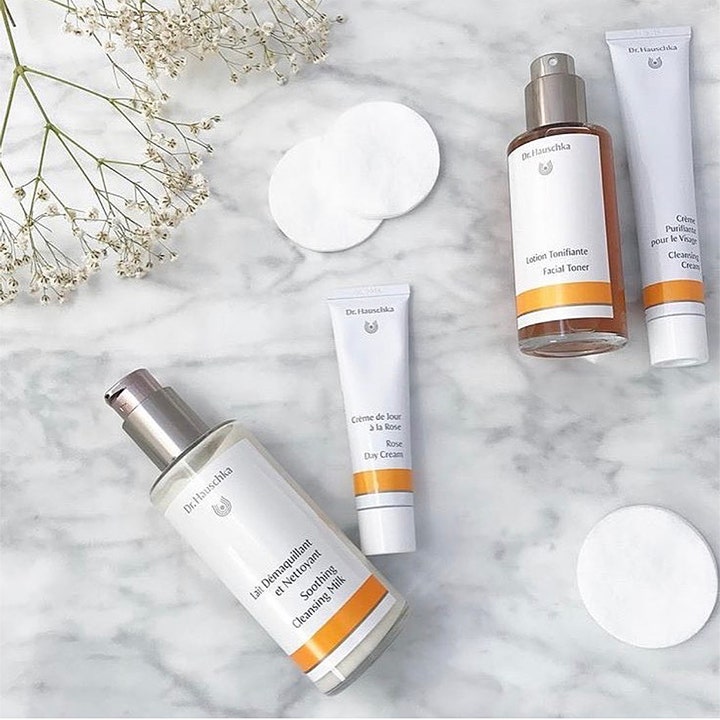 Dr. Hauschka Cleansing Cream 50 ml kirkastava puhdistusvoide aseteltuna marmorille kukkien ja vanulappujen kera