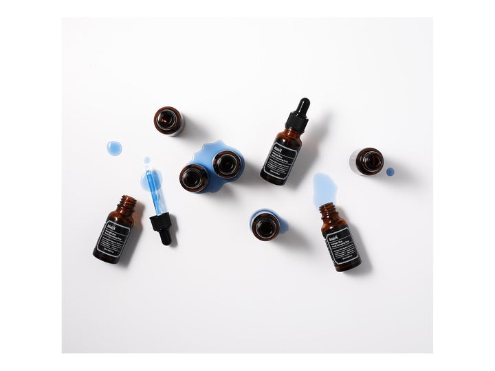 Klairs Midnight Blue Youth Activating Drop 20 ml elvyttävä seerumi ruskeissa lasipulloissa ja sinisiä pisaroita.