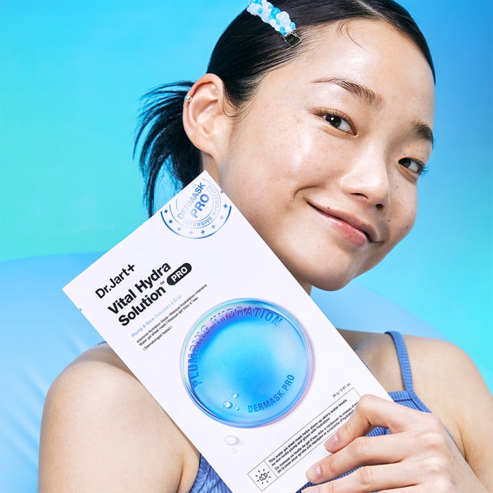 Dr.Jart+ Dermask Vital Hydra Solution Pro 26 g kosteuttava kangasnaamio nainen pitelee valkoista pakkausta.