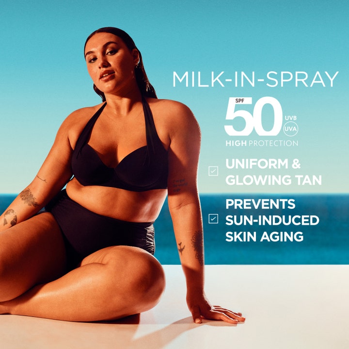 Garnier Ambre Solaire Ideal Bronze 150 ml SPF 50 aurinkosuihke nainen mustissa bikineissä meren rannalla.