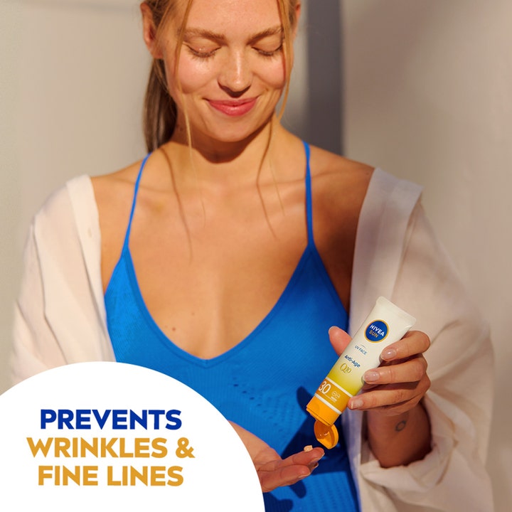 NIVEA Sun UV Face Anti Age Q10 Cream 50 ml spf 50 aurinkovoide ehkäisee ryppyjä naisen levittäessä voidetta.