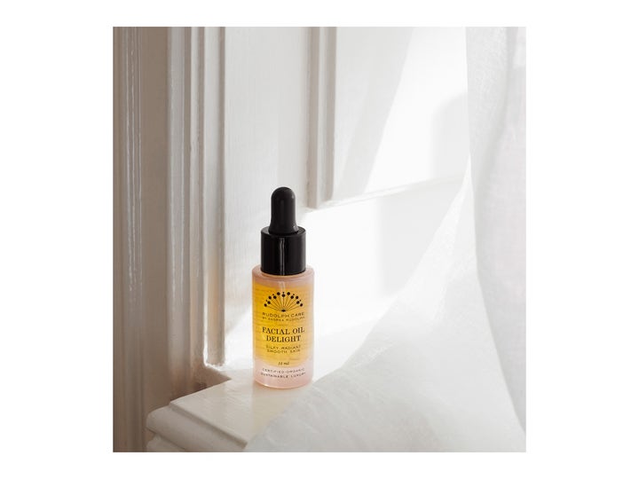 Rudolph Care Facial Oil Delight 15 ml heleyttävä ansiktsöljy pipettipullossa valoisalla ikkunalaudalla.