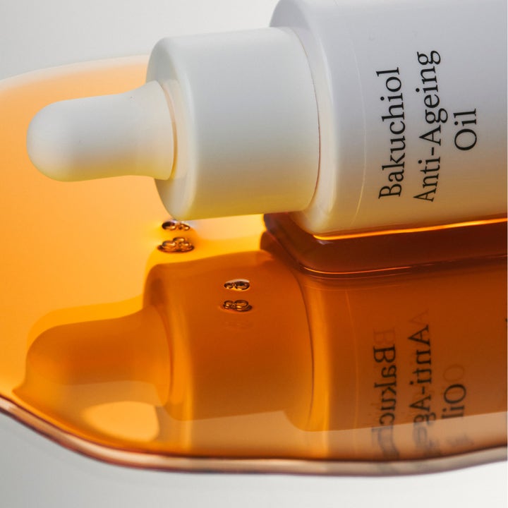 Jorgobé Bakuchiol Anti-Ageing Oil 30 ml silottava kasvoöljy valkoisessa pullossa kultaisen öljyn ympäröimänä.