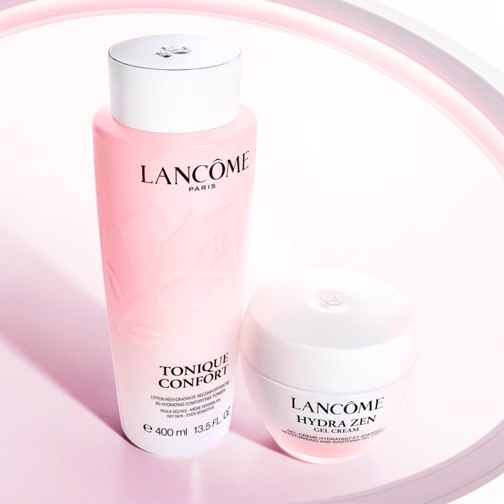 Lancôme Tonique Confort 400 ml kosteuttava kasvovesi ja Hydra Zen -geelivoide vaaleanpunaisessa asetelmassa.
