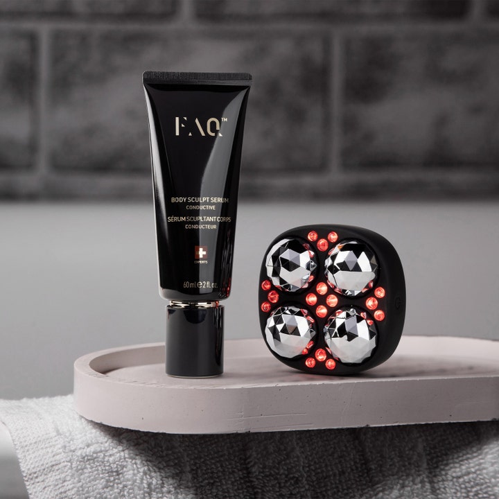 FAQ Swiss FAQ Body Sculpt Serum 60 ml kiinteyttävä vartaloseerumi mustassa tuubissa ja hierontalaite punaisilla valoilla