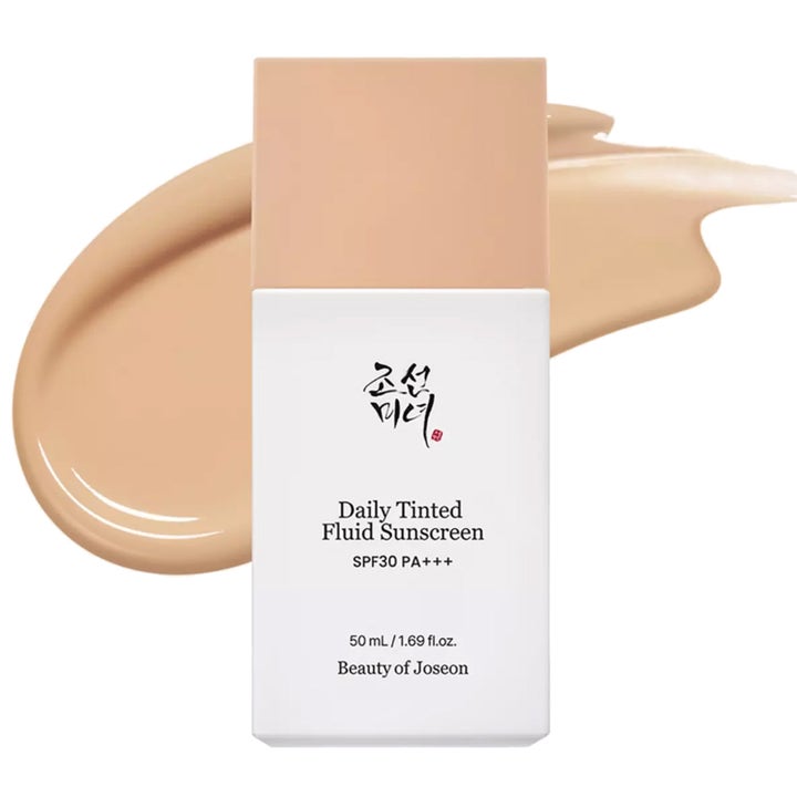 Beauty of Joseon Daily Tinted Fluid Sunscreen 50 ml tasoittava aurinkovoide valkoisessa pullossa beigellä voidepyyhkäisyllä.