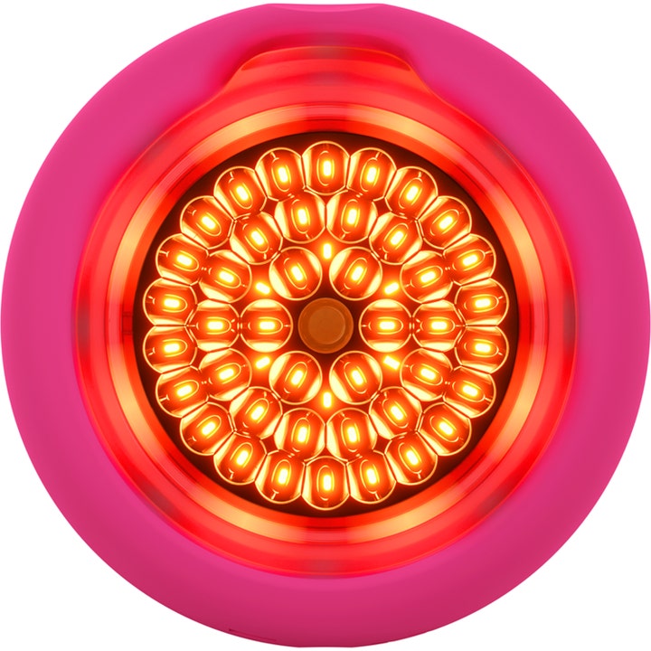 Foreo UFO 2 Fuchsia kirkastava kasvolaite on vaaleanpunainen pyöreä laite jossa on hehkuva hunajakennomainen LED-valo.