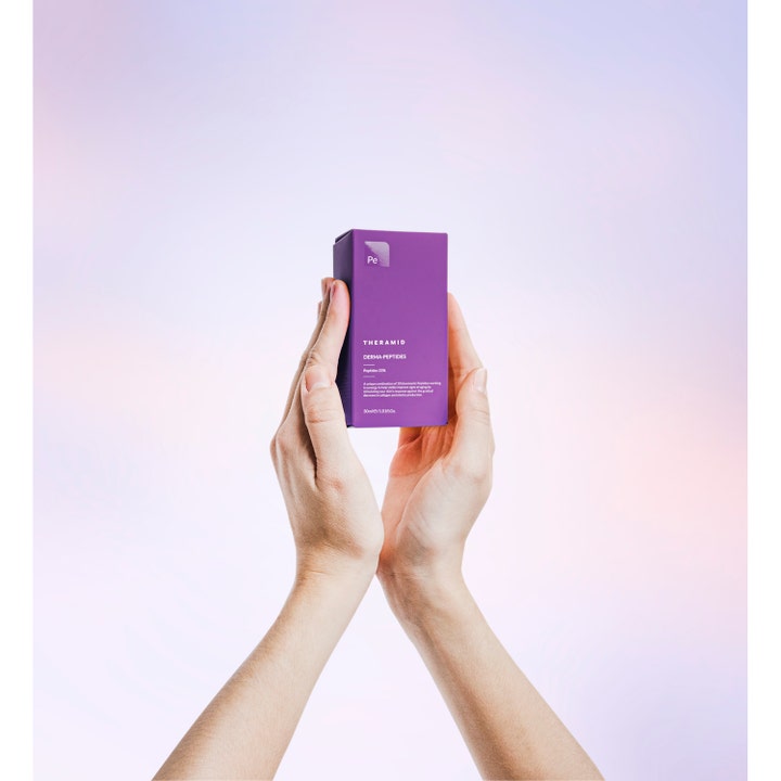 Niche Beauty Lab Theramid Derma-Peptides 35% 30 ml elvyttävä seerumi violetissa pakkauksessa käsien välissä.