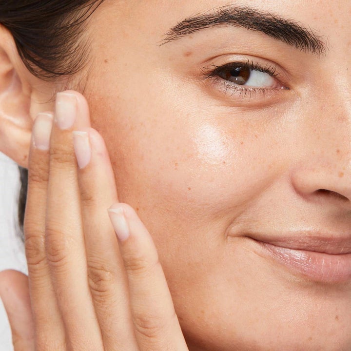 Dermalogica Retinol Clearing Oil Duo kirkastava kasvoöljy lähikuvassa hymyilevän naisen kuulaalla iholla.