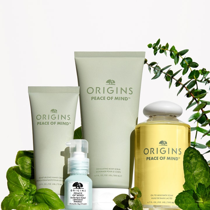 Origins Peace Of Mind Moisturizing Hand Cream 75 ml kosteuttava käsivoide ja muita sarjan tuotteita kasvien ympäröimänä.