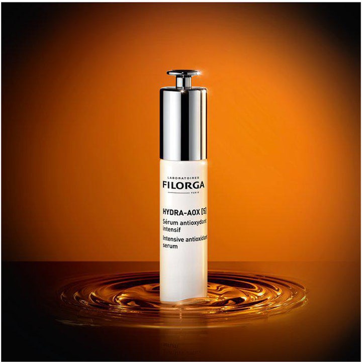 Filorga Hydra-Aox [5] Intensive Antioxidant Serum 30 ml seerumi valkoisessa pullossa oranssilla aaltoilevalla taustalla.