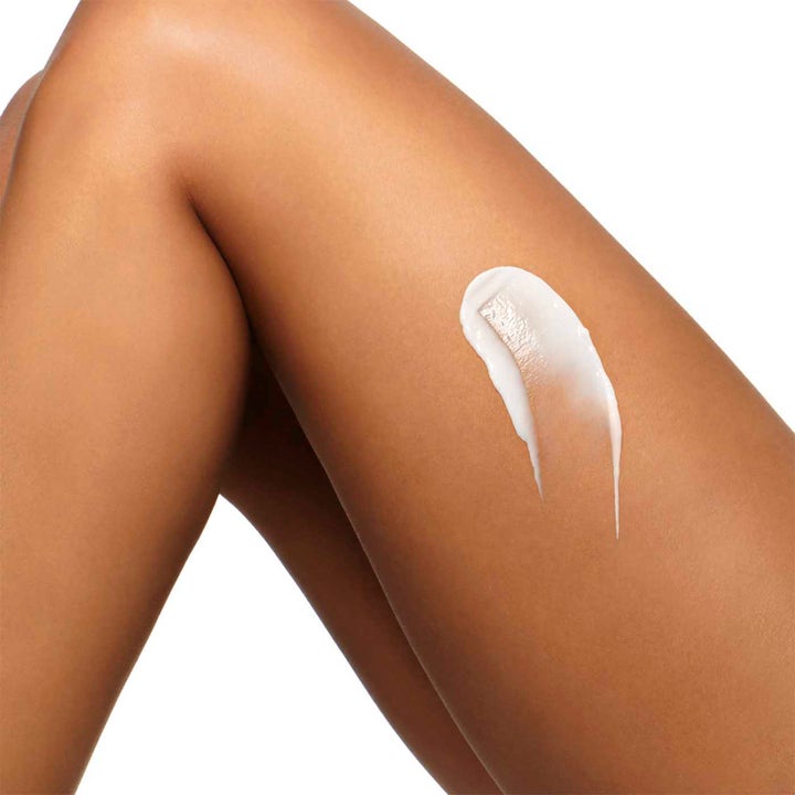 Clarins Hydrating Body-Smoothing Moisture Milk 400 ml kosteuttava vartalovoide ja valkoinen voidekoostumus säärellä