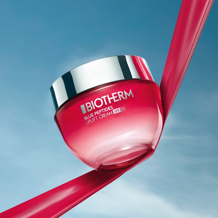 Biotherm Blue Peptides Uplift Cream 50 ml kiinteyttävä päivävoide SPF30 punaisen nauhan päällä taivasta vasten