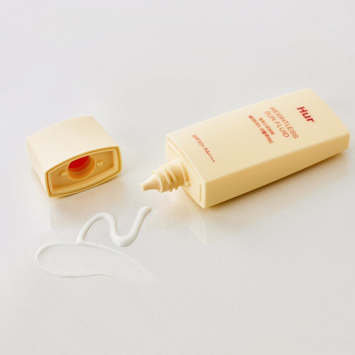 House of Hur Weightless Sun Fluid 50 ml aurinkovoide SPF 50 ja keltaisesta tuubista pursotettu ohut valkoinen koostumus.