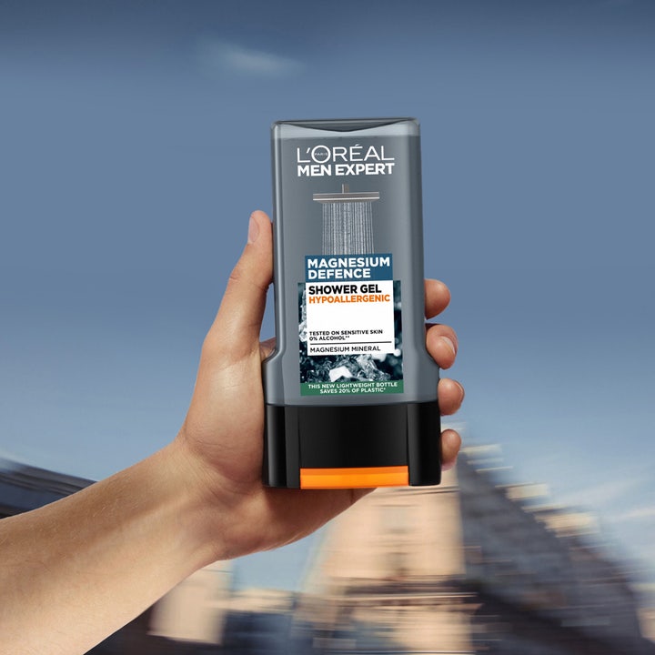 L'Oréal Paris Men Expert Magnesium Defence 300 ml suihkugeeli herkälle iholle kädessä pidettynä harmaassa pullossa