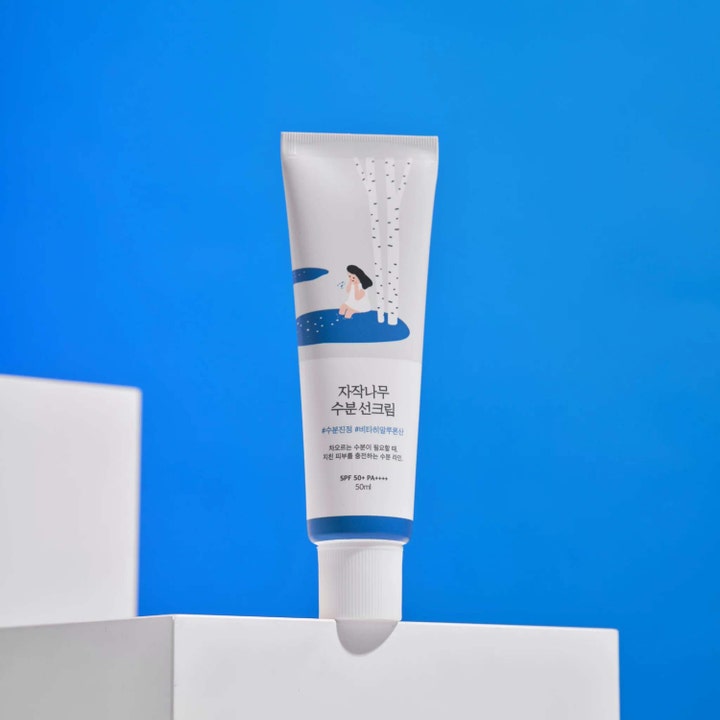 Round Lab Birch Juice Moisturizing Sunscreen 50 ml kosteuttava aurinkovoide valkoisessa tuubissa sinisellä taustalla
