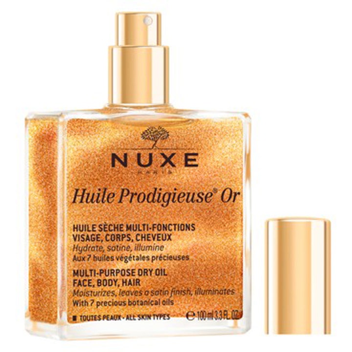 Nuxe Huile Prodigieuse Or 100 ml heleyttävä kuivaöljy kultaisella hohdolla neliönmuotoisessa lasipullossa.