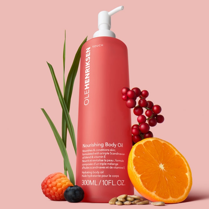 Ole Henriksen TOUCH Nourishing Body Oil 300 ml ravitseva vartaloöljy korallinvärisessä pullossa marjojen ja appelsiinin kera.