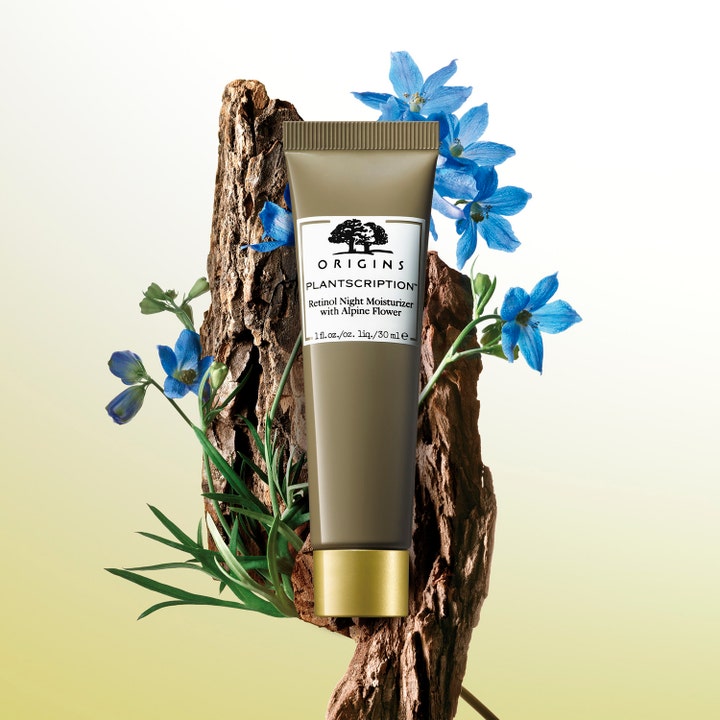 Origins Plantscription Retinol Night Moisturizer 30 ml yövoide oliivinvihreässä tuubissa sinisten kukkien ja kaarnan kera.