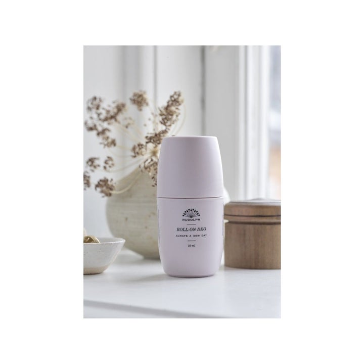 Rudolph Care Acai Keep On Rolling Duo 50 ml raikastava deodorantti vaaleanpunaisessa pullossa tyylikkäässä miljöössä.